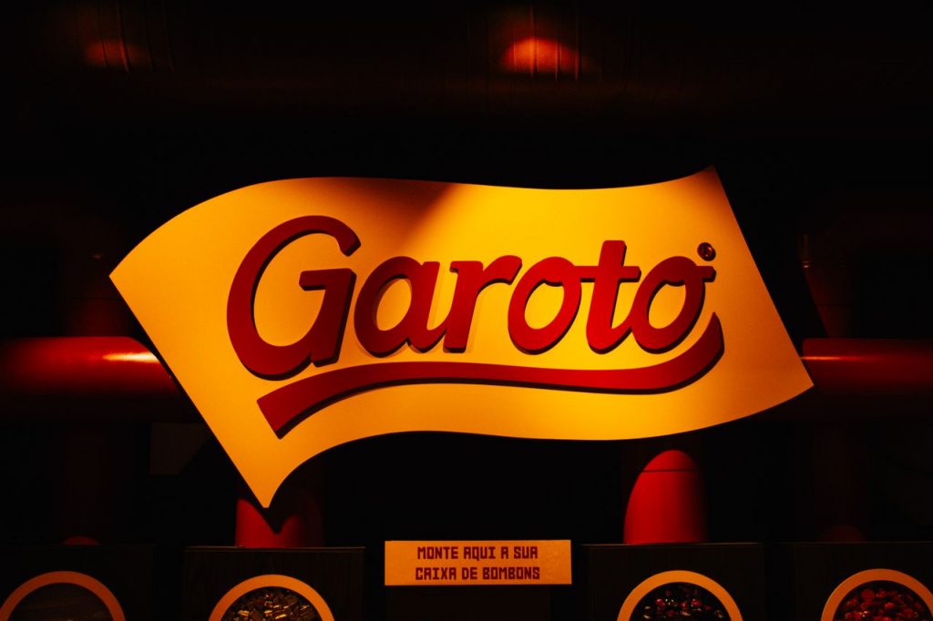 Illuminated Garoto chocolate logo sign with vibrant red and yellow colors, creating a bold and vivid atmosphere.